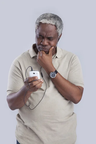 Пожилой человек пользуется мобильным телефоном — стоковое фото