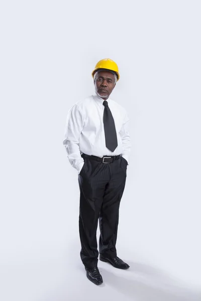 Aged businessman in helmet looks seriously — Stock Photo, Image