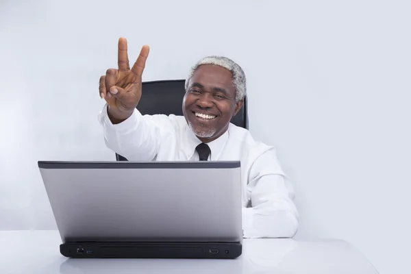 Homem de negócios envelhecido sorrisos e gestos em cinza — Fotografia de Stock