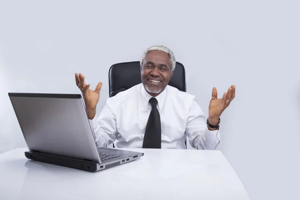 Homme d'affaires âgé avec des sourires et des gestes d'ordinateur portable — Photo