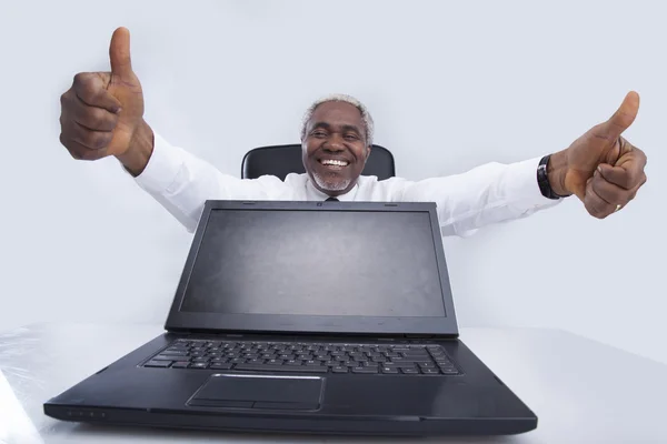 Uomo d'affari anziano con computer portatile sorrisi e gesti — Foto Stock