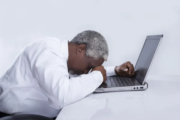 Hombre de negocios envejecido se duermen cerca de la computadora portátil — Foto de Stock