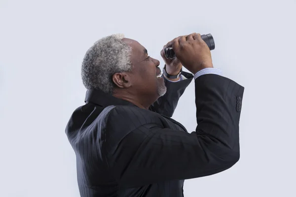 yaşlı işadamı dürbün görünüyor