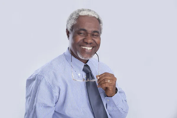 Homem de negócios com olhares de óculos e sorrisos em cinza — Fotografia de Stock