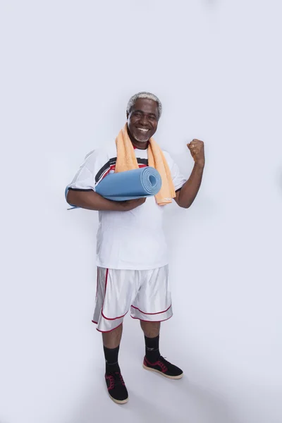 Deportista sonriendo con toalla y alfombra —  Fotos de Stock