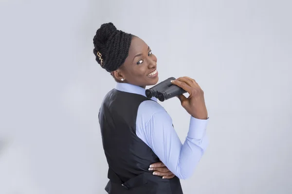Businesswoman holds binoculars on gray — Stock Photo, Image