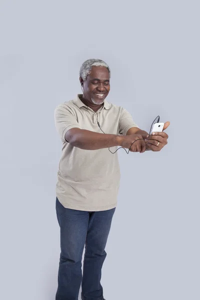 Hombre de edad utiliza el teléfono celular Fotos de stock libres de derechos