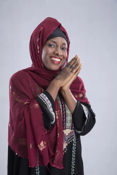 Arap kadın gri üzerine gülümseyerek poz