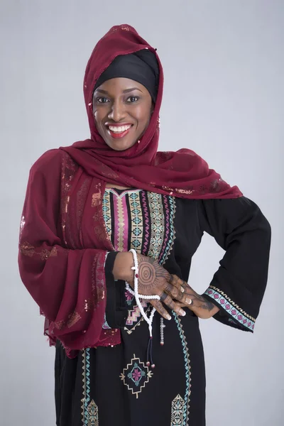 Arap kadın gri üzerine gülümseyerek poz
