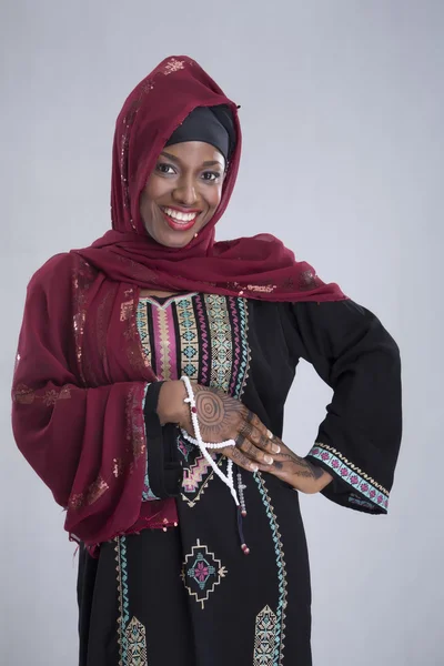 Arap kadın gri üzerine gülümseyerek poz