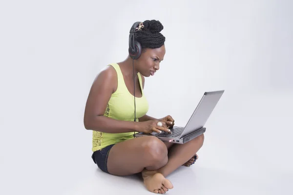 Vrouw zit met hoofdtelefoons en laptop geïsoleerd — Stockfoto