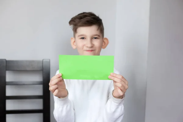 Engraçado menino segurando folha de papel verde para o seu texto — Fotografia de Stock
