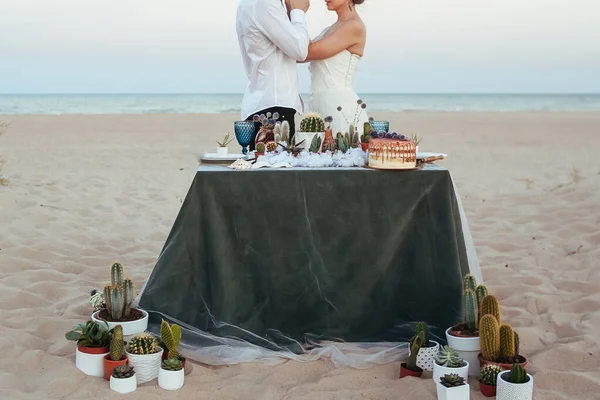 Yeni evlilerin önünde süslemeli düğün masası.