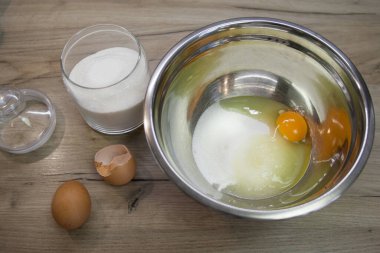 Kasede beyaz şeker ve yumurta ve ahşap arka planda iki yumurta. Çörek, turta ve bisküvi yapmak için ikinci adım. Pişirme işlemi adım adım. 