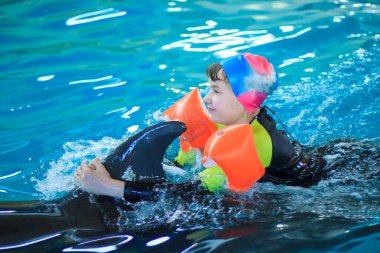 Yunuslarla yunuslarda yüzen mutlu küçük kız.