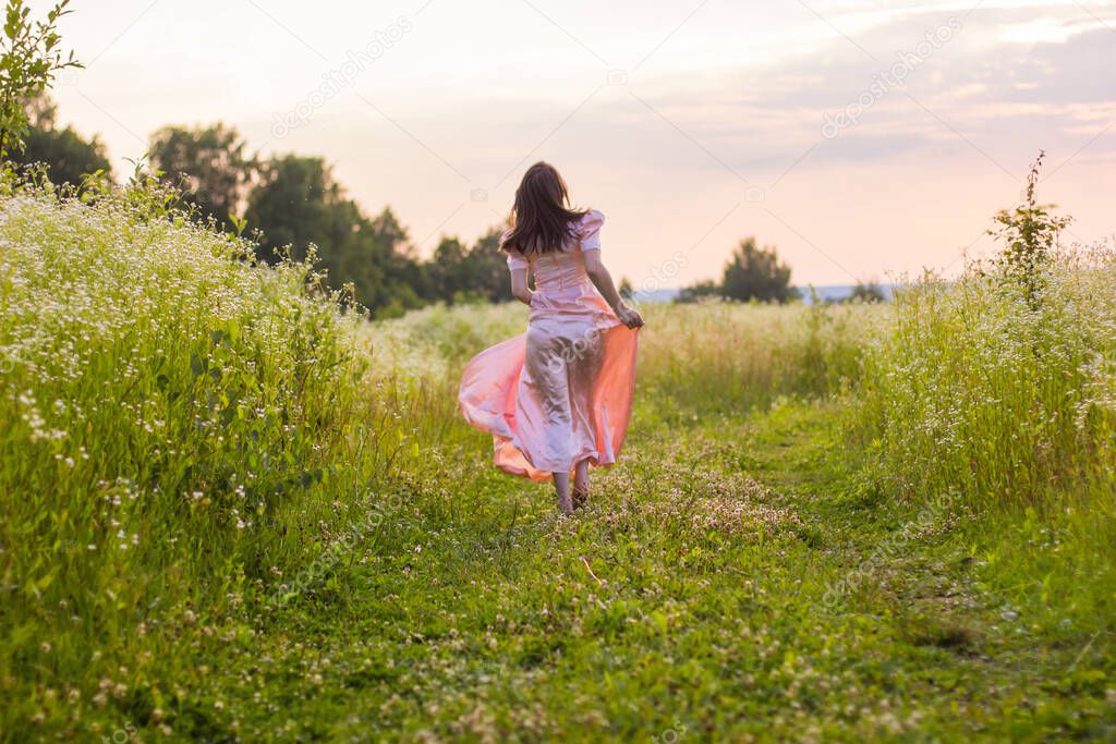 girl running across the field in a pink dress