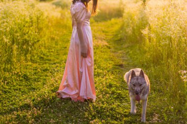 Pembe elbiseli kız tarlada dikiliyor.