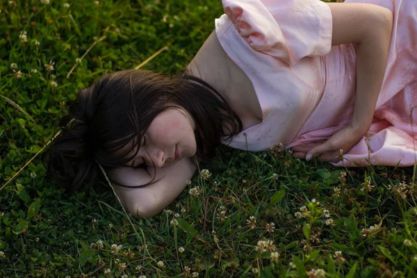 Foto de una hermosa mujer dormida en el fild con flores silvestres —  Fotos de Stock