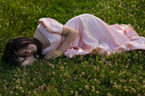 Foto de bela mulher dormindo no fild com flores silvestres — Fotografia de Stock