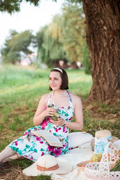 Eine junge Frau sitzt auf einem Picknick in einem Park — Stockfoto