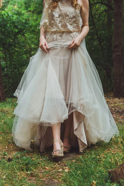 Braut hält den Boden des Brautkleides und zeigt Schuhe — Stockfoto