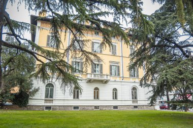 Açılış balkonlu ev ve gri ahşap panjurlu pencereler.