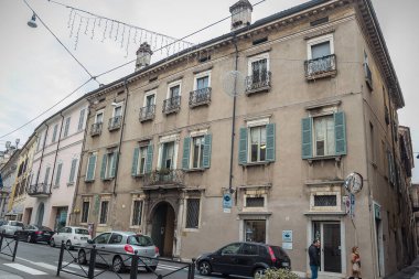 Açılış balkonlu ev ve gri ahşap panjurlu pencereler.