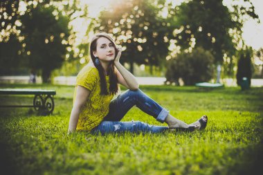 Akşamları çimenlerde oturan mutlu kadın.