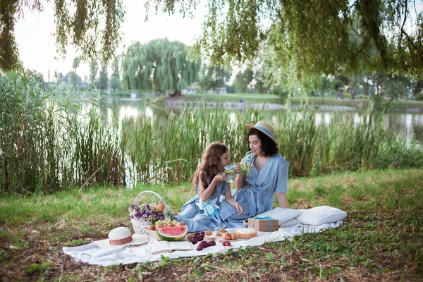 Matka i córka na pikniku w parku nad brzegiem rzeki — Zdjęcie stockowe