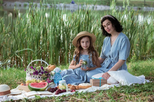 Matka i córka na pikniku w parku nad brzegiem rzeki — Zdjęcie stockowe