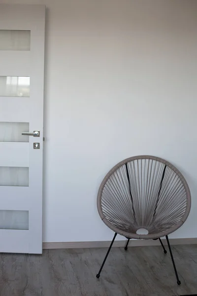 Część pokoju z krzesłem cappuccino, białą ścianą, szarą podłogą i białymi drzwiami — Zdjęcie stockowe