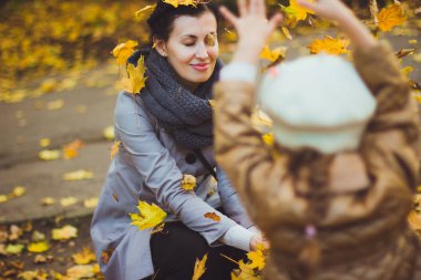 Genç anne ve kızı sonbaharda eğleniyorlar.