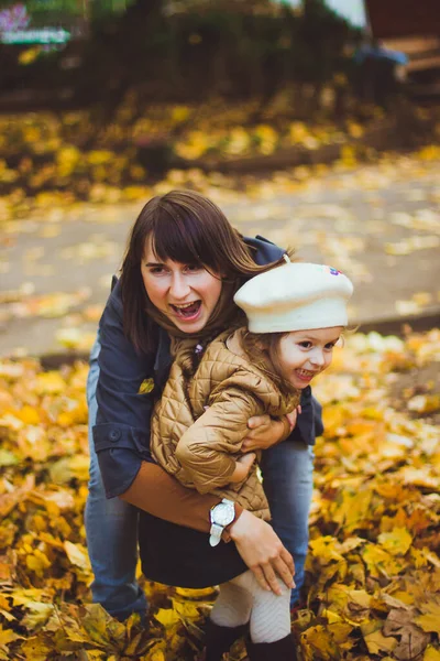 年轻的母亲和她的女儿在秋天玩得很开心 — 图库照片