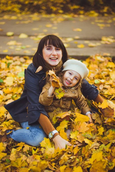 Young mother and her daughter have fun at autumn — Stock Photo, Image