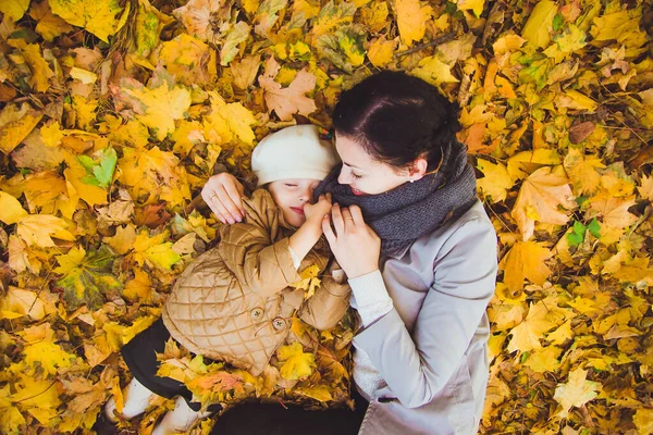 Mladá matka a její dcera se baví na podzim — Stock fotografie