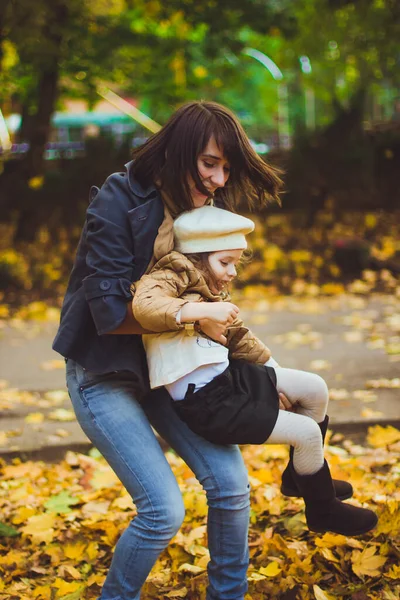 年轻的母亲和她的女儿在秋天玩得很开心 — 图库照片