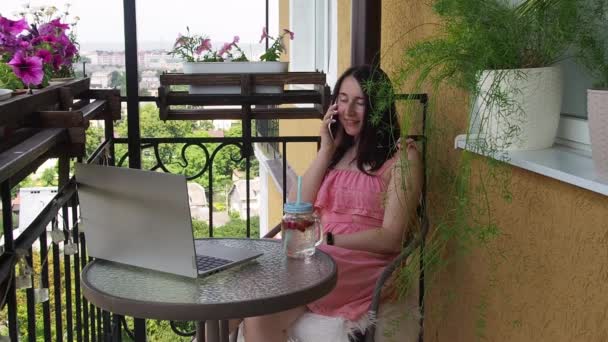 Γυναίκα που χρησιμοποιεί φορητό υπολογιστή και smartphone στο μπαλκόνι — Αρχείο Βίντεο
