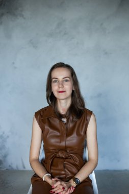 Kahverengi saçlı, kahverengi elbiseli iş kadını.