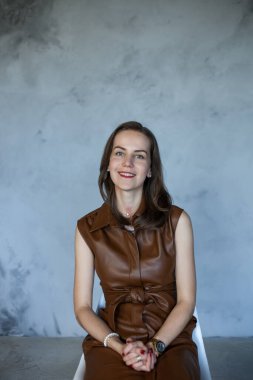 Kahverengi saçlı, kahverengi elbiseli iş kadını.