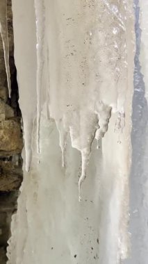 Şelale donmuştu. Baharda büyük buz saçakları vardı. Şafak vakti güneş altında su damlacıklarıyla. Donmuş şelale, ilkbaharın başlarında güneşin sıcak ışınları altında erir. Kış sonu. Sarkıtlar erir