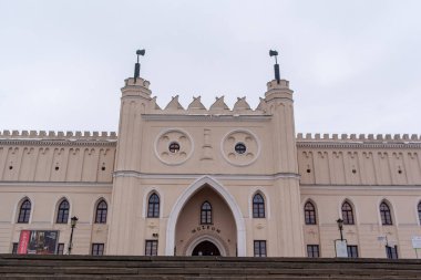 Lublin, Polonya, 25 Kasım 2025 Lublin 'deki tarihi şatonun önü. Büyük bir müze, kış manzarasında karmaşık bir mimari ile ayakta duruyor. Kar, gri gökyüzünün altındaki zemini kaplıyor..