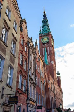 Gdansk, Polonya, 27 Kasım 2025: Gdansk 'ta bir sokak. Uzun saat kulesi ve caddenin sonundaki belediye binası..