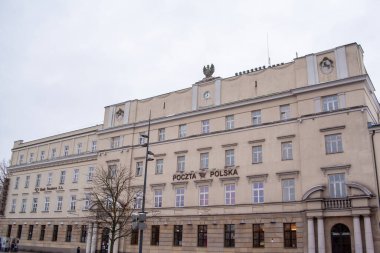 Lublin, Polonya, 25 Kasım 2025: Polonya 'daki postane klasik mimarisi ile ayakta duruyor. İnsanlar sokakta yürürken yağmur bulutları tepemizde toplanıyor..
