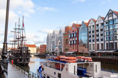 Gdansk, Polonya, 27 Kasım 2025: Gdansk rıhtımı boyunca iki tekne rıhtıma yanaşmış ve su yolu ve tepede mavi bir gökyüzü vardır..