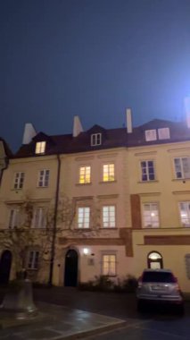 Varşova, Polonya, 26 Kasım 2025: Parlak ışıklar tarihi bir şehir bölgesindeki eski binaları aydınlatıyor.