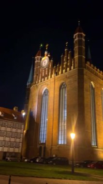 Gdansk, Polonya, 27 Kasım 2025: Polonya 'nın Gdansk kentindeki St. Marys Kilisesi' nin dış görünüşü. Kilise aydınlandı ve arabalar caddenin yakınına park edildi..