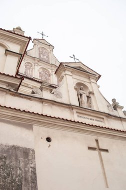Polonya, St. Joseph Kilisesi, Lublin. Çatısı karla kaplı küçük bir kasabada tarihi bir kilise duruyor. Sahne bulutlu gökyüzü ile kışın geçer. Kilisenin detayları.