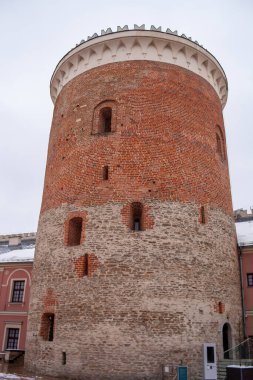 Lublin, Polonya. Romanesk kale kulesi. Lublin 'deki en eski binalardan biri. Büyük bir kırmızı tuğla kule kışın görülebilir, eski yapılar ve boş uzayla çevrilidir. Kar zemini kaplıyor..