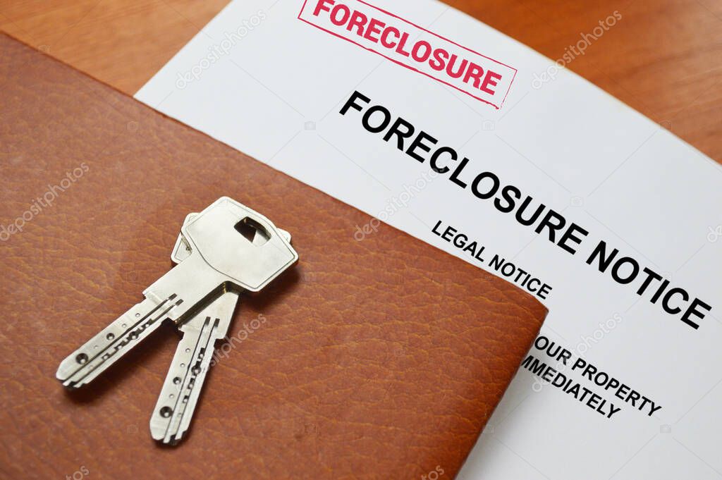 A foreclosure Notice And House Keys on a table with space for text
