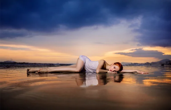 Zachód słońca, dziewczyna leżąc na plaży — Zdjęcie stockowe
